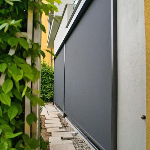 Schiebeanlage mit ausgefahrener Zip-Senkrechtmarkise Seitenansicht